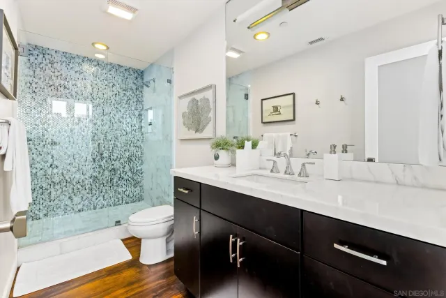 a bathroom with a sink toilet a mirror and shower