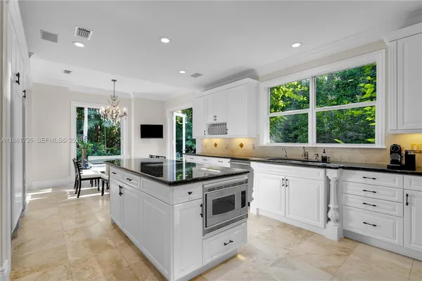 a kitchen with stainless steel appliances granite countertop a stove a sink a counter space and chairs