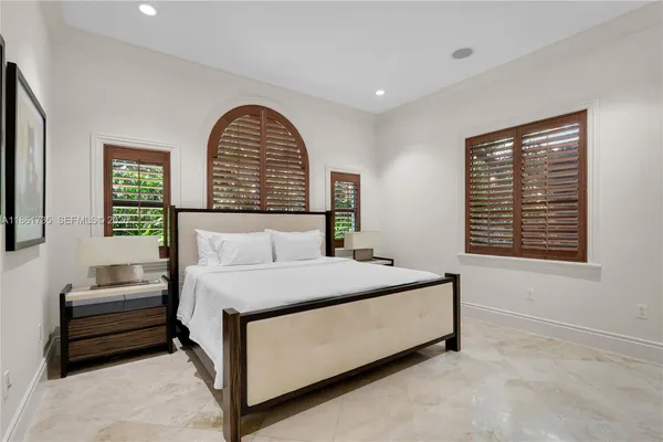 a bed sitting in a bedroom next to a window