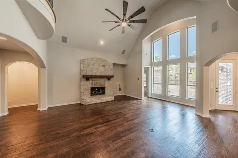 wooden floor fireplace and windows in an empty room