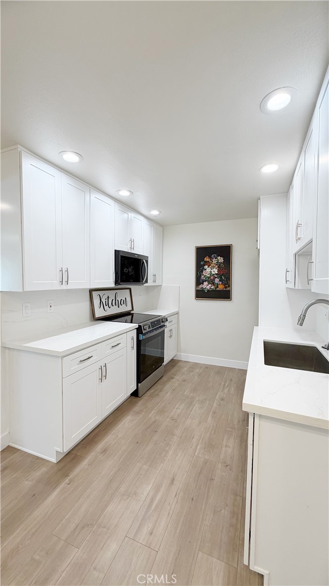 212 South Kraemer, Unit 2208 Placentia, CA 92870 - Photo 8 of 16 a kitchen with granite countertop white cabinets and white appliances