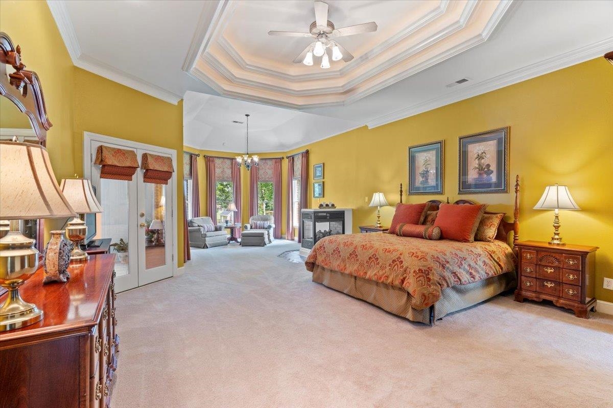 1226 Oak Lake Circle Collierville, TN 38017 - Photo 19 of 39 a spacious bedroom with a bed couch chandelier and a window