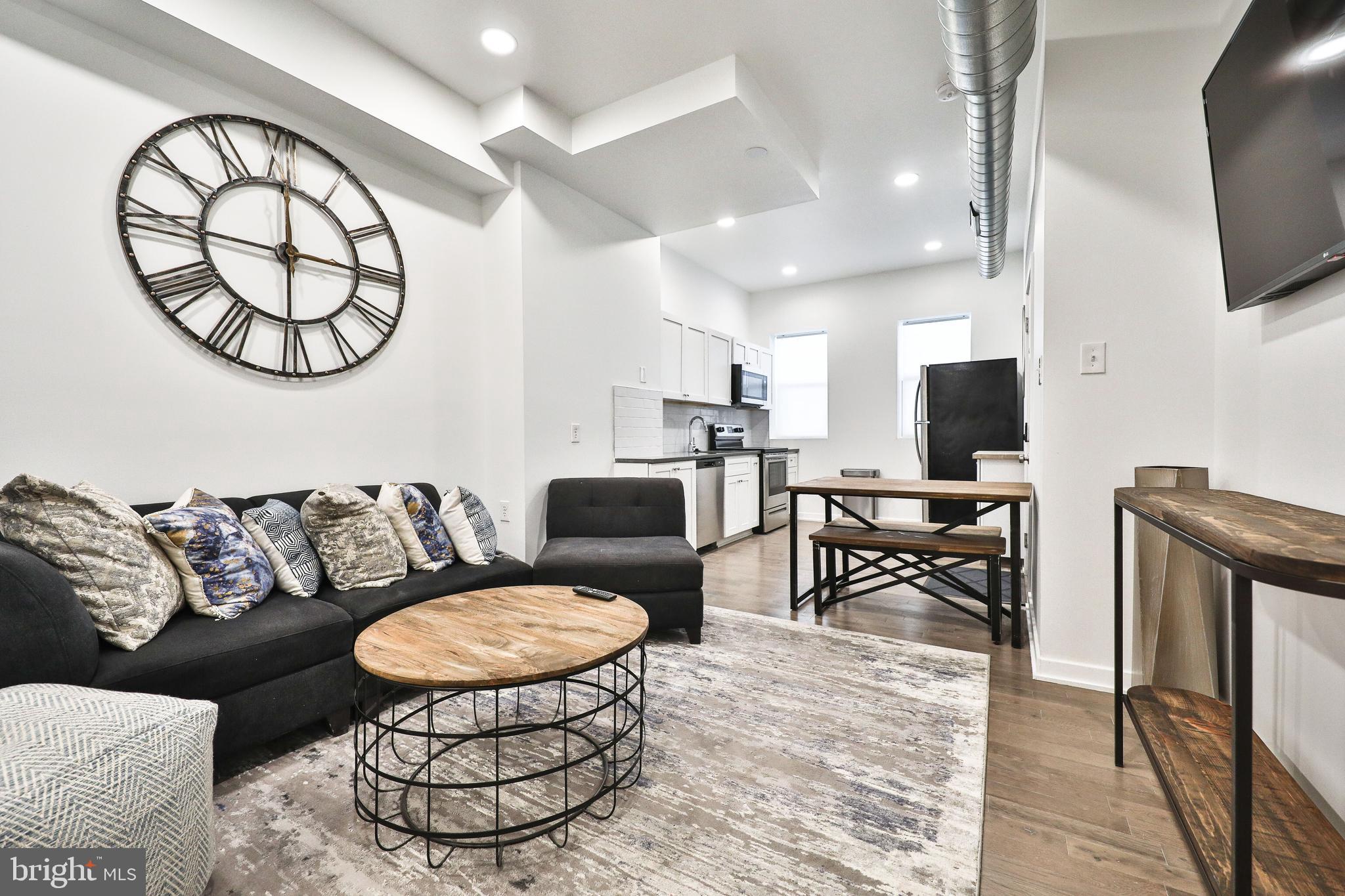 3217 Turner Street Philadelphia, PA 19121 - Photo 3 of 18 a living room with furniture a flat screen tv and kitchen view