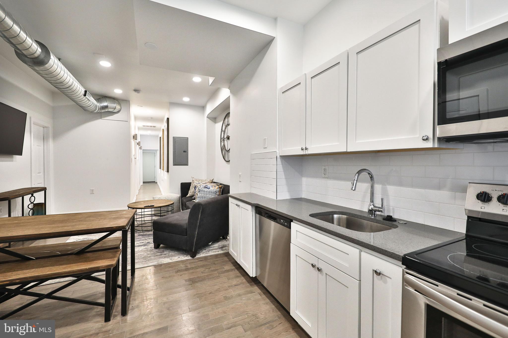 3217 Turner Street Philadelphia, PA 19121 - Photo 8 of 18 a kitchen with stainless steel appliances granite countertop a sink a stove a refrigerator and cabinets