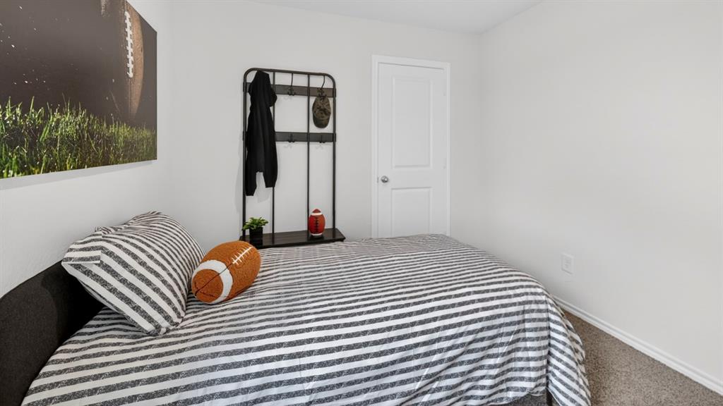 3514 Spring Time Street Terrell, TX 75126 - Photo 21 of 26 Bedroom featuring light gray walls, gray carpet, white baseboards, and a white two-panel door with a round doorknob