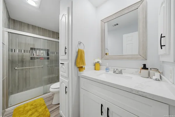 a bathroom with a granite countertop sink a toilet and shower