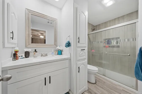 a bathroom with a granite countertop sink toilet and shower