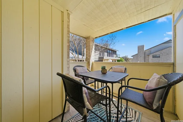 a balcony with a table and chairs