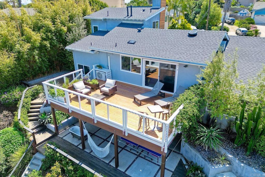 an aerial view of a house with balcony and outdoor seating