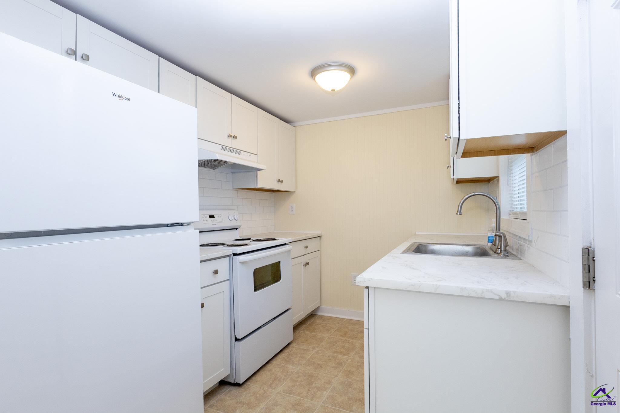156 Churchwell Road Cochran, GA 31014 - Photo 10 of 20 a kitchen with a sink a stove and refrigerator