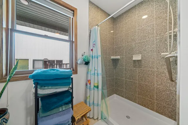 a spacious bathroom with a double vanity sink a mirror and a shower