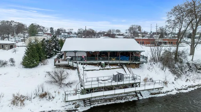 a view of a house with roof deck covered with snow in the background