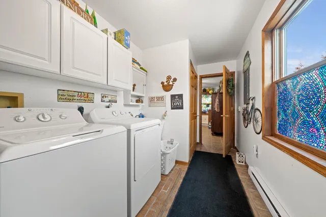 a utility room with fridge dryer and washer