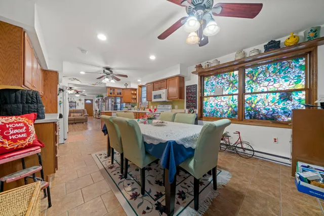 a dining room with furniture a rug a flat screen tv and a chandelier