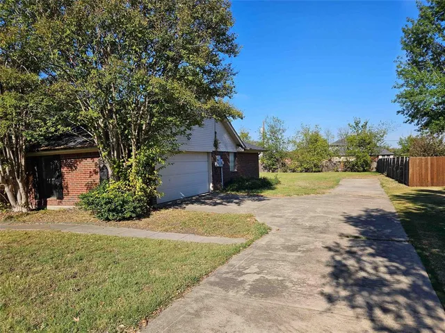 a view of a house with backyard and tree