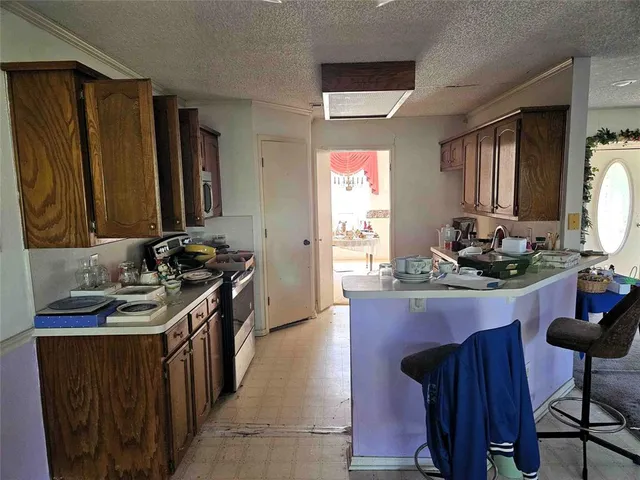 a kitchen with granite countertop a sink stove and cabinets