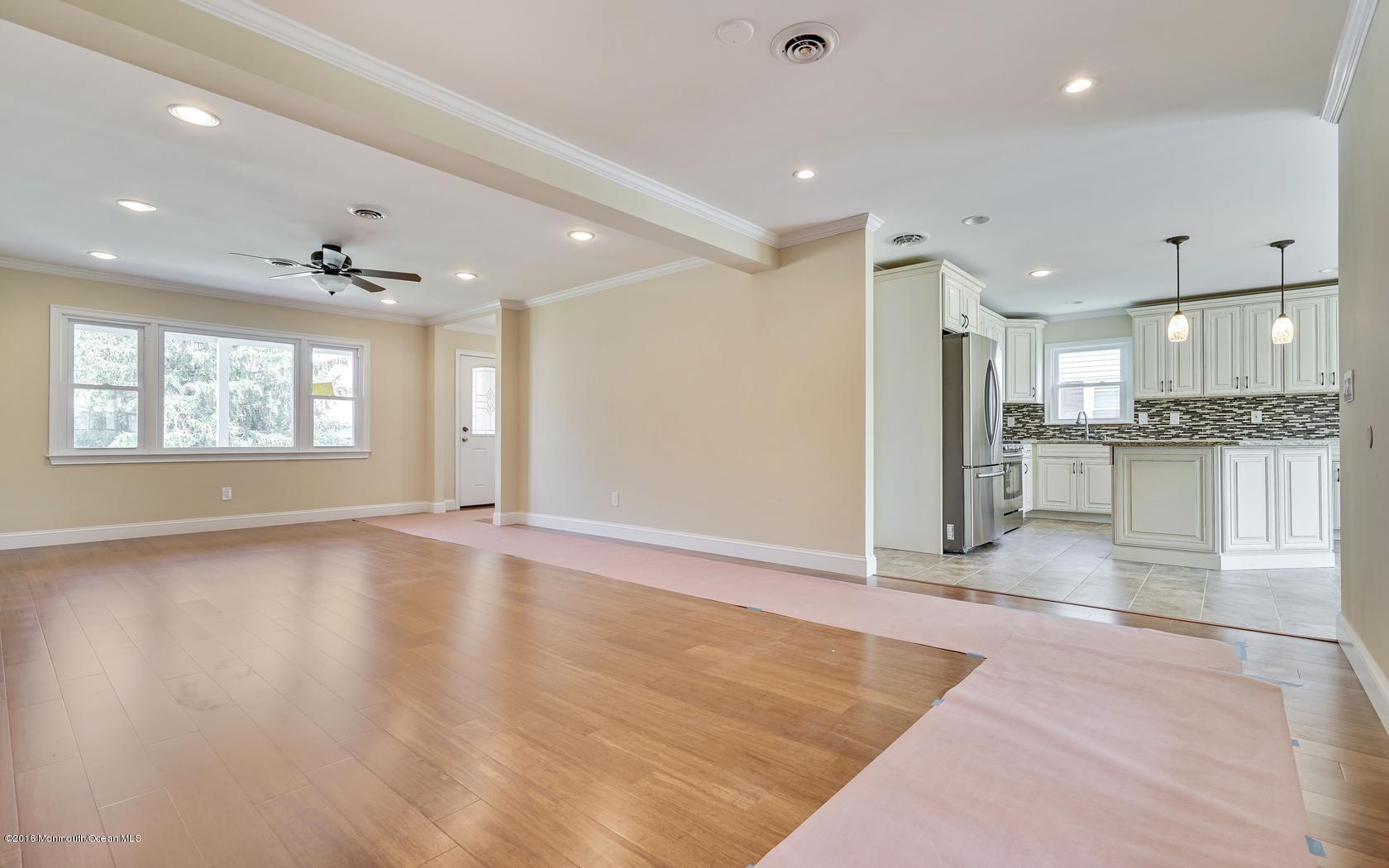 7 Coventry Road Toms River, NJ 08757 - Photo 14 of 34 an empty room with wooden floor and a kitchen