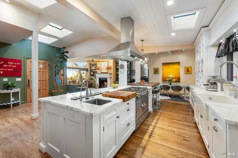 a large white kitchen with stainless steel appliances lots of counter space and window