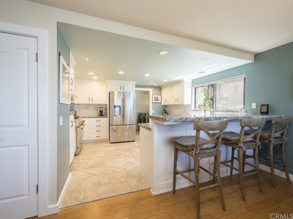 2630 Maple Avenue Morro Bay, CA 93442 - Photo 12 of 49 a open kitchen with stainless steel appliances kitchen island granite countertop a table and chairs in it