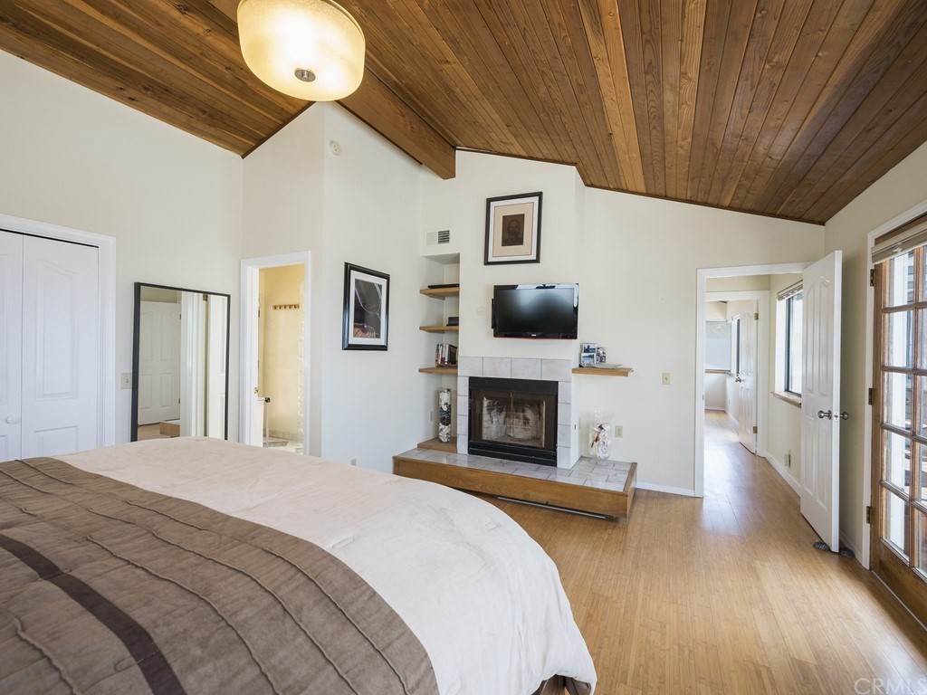 2630 Maple Avenue Morro Bay, CA 93442 - Photo 27 of 49 a spacious bedroom with a bed and a fireplace