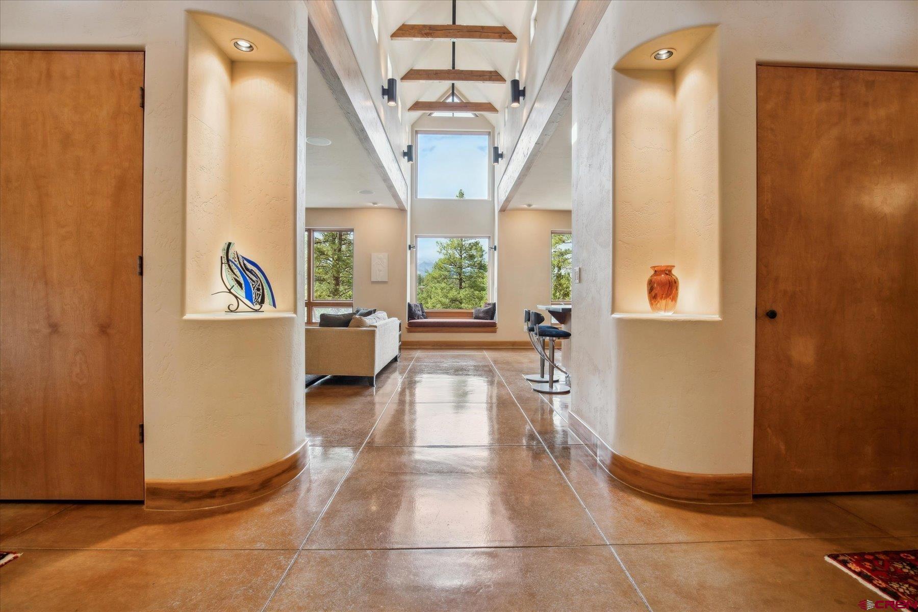 a view of a hallway with wooden floor and furniture