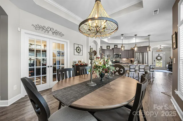 a view of a dining room with furniture wooden floor and chandelier