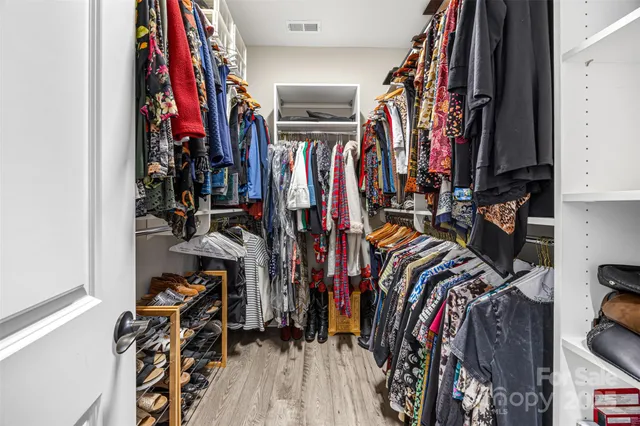 a view of walk in closet with clothes
