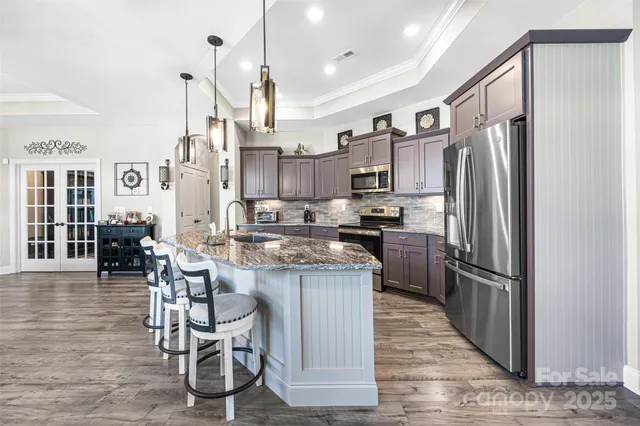 a kitchen with granite countertop a counter space stainless steel appliances and cabinets