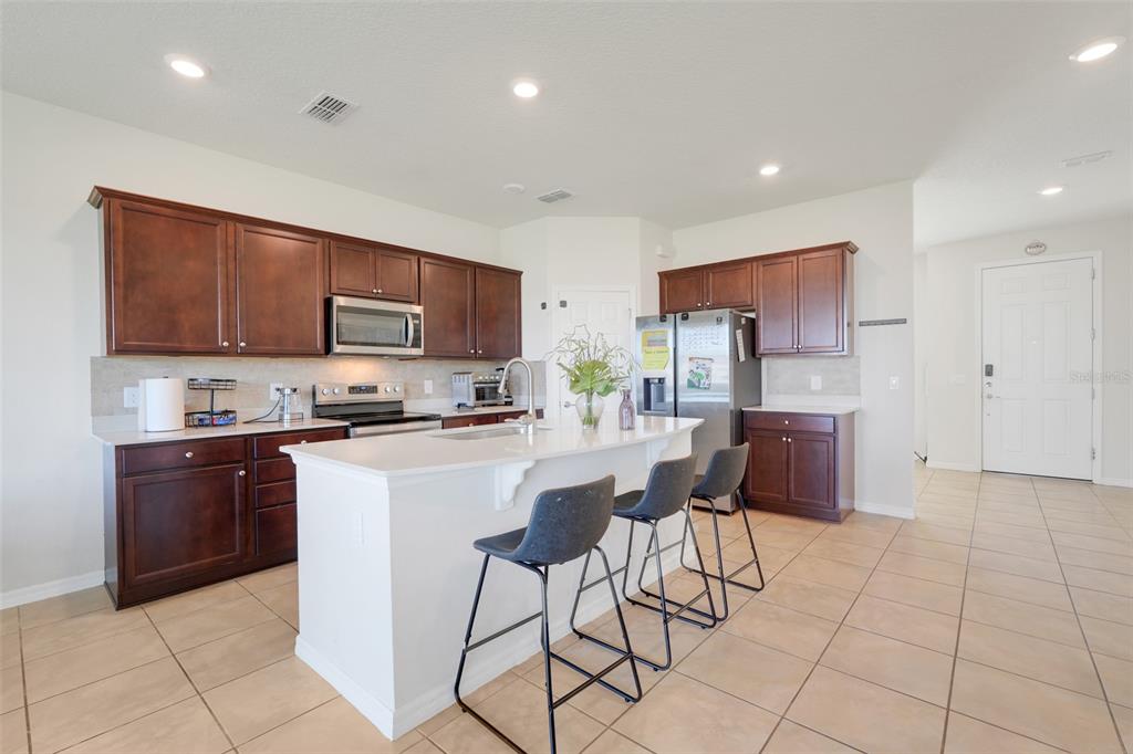 2611 Hilltop Loop Apopka, FL 32712 - Photo 11 of 46 a kitchen with stainless steel appliances granite countertop a stove a sink a microwave and a refrigerator