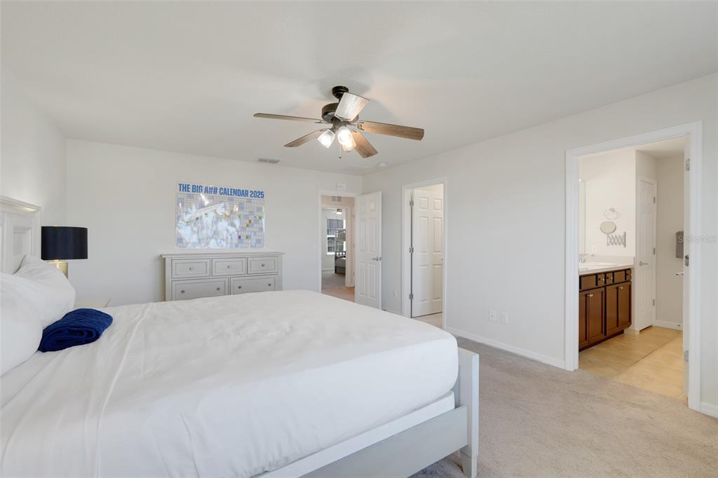 2611 Hilltop Loop Apopka, FL 32712 - Photo 16 of 46 a bedroom with a large bed and a chandelier