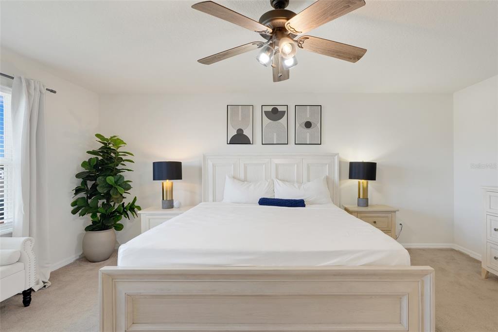 2611 Hilltop Loop Apopka, FL 32712 - Photo 6 of 46 a bedroom with a large bed and a chandelier
