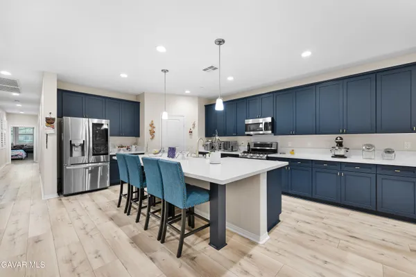 a large kitchen with stainless steel appliances kitchen island granite countertop a large counter top and a stove