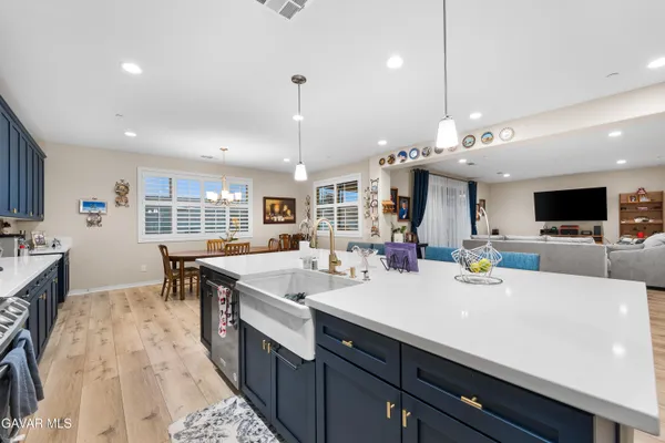 a kitchen with kitchen island granite countertop a sink dishwasher stove and wooden cabinets