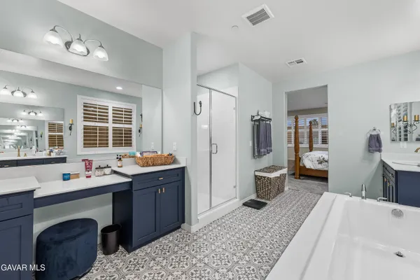 a bedroom with a bed and dresser with mirror