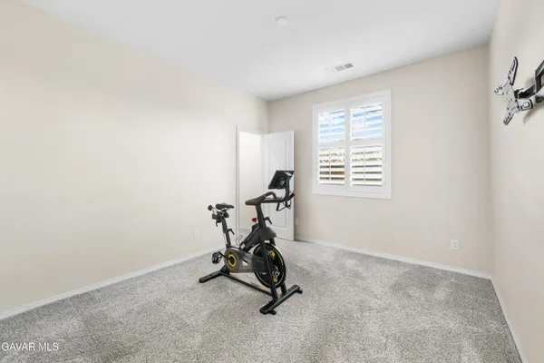 a bedroom with a bed and a refrigerator