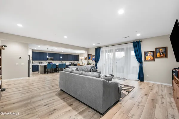 a living room with furniture and view of kitchen