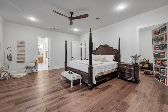 a bedroom with a large bed and wooden floor