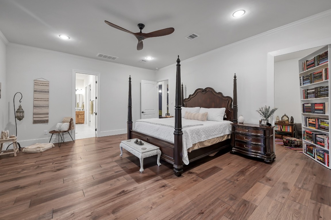 15937 Stagecoach Road Stagecoach, TX 77355 - Photo 21 of 50 a spacious bedroom with a bed a dresser and a book shelf