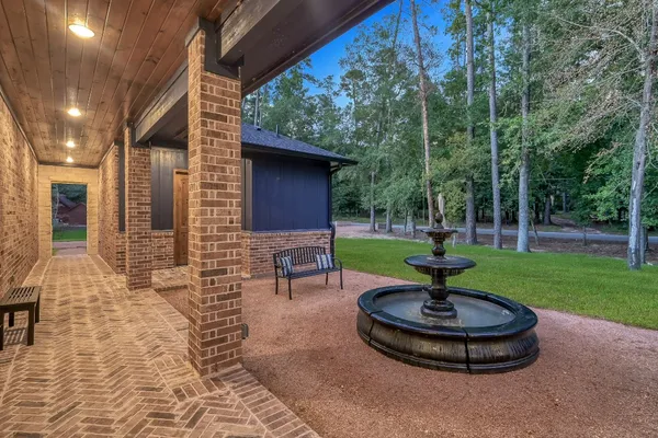 a view of a backyard with table and chairs potted plants and large tree