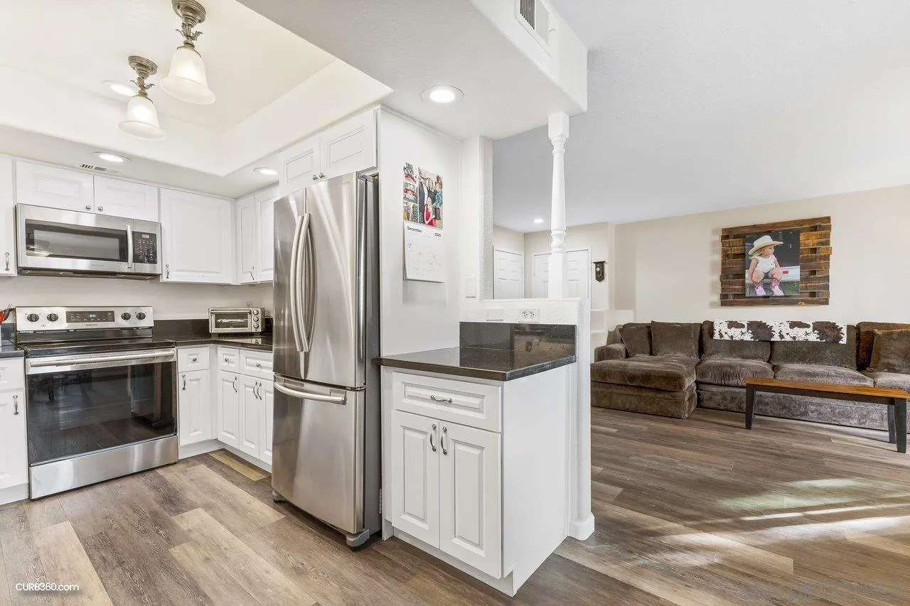 13967 Midland Road Poway, CA 92064 - Photo 12 of 37 a kitchen with granite countertop a refrigerator oven a sink dishwasher and white cabinets with wooden floor
