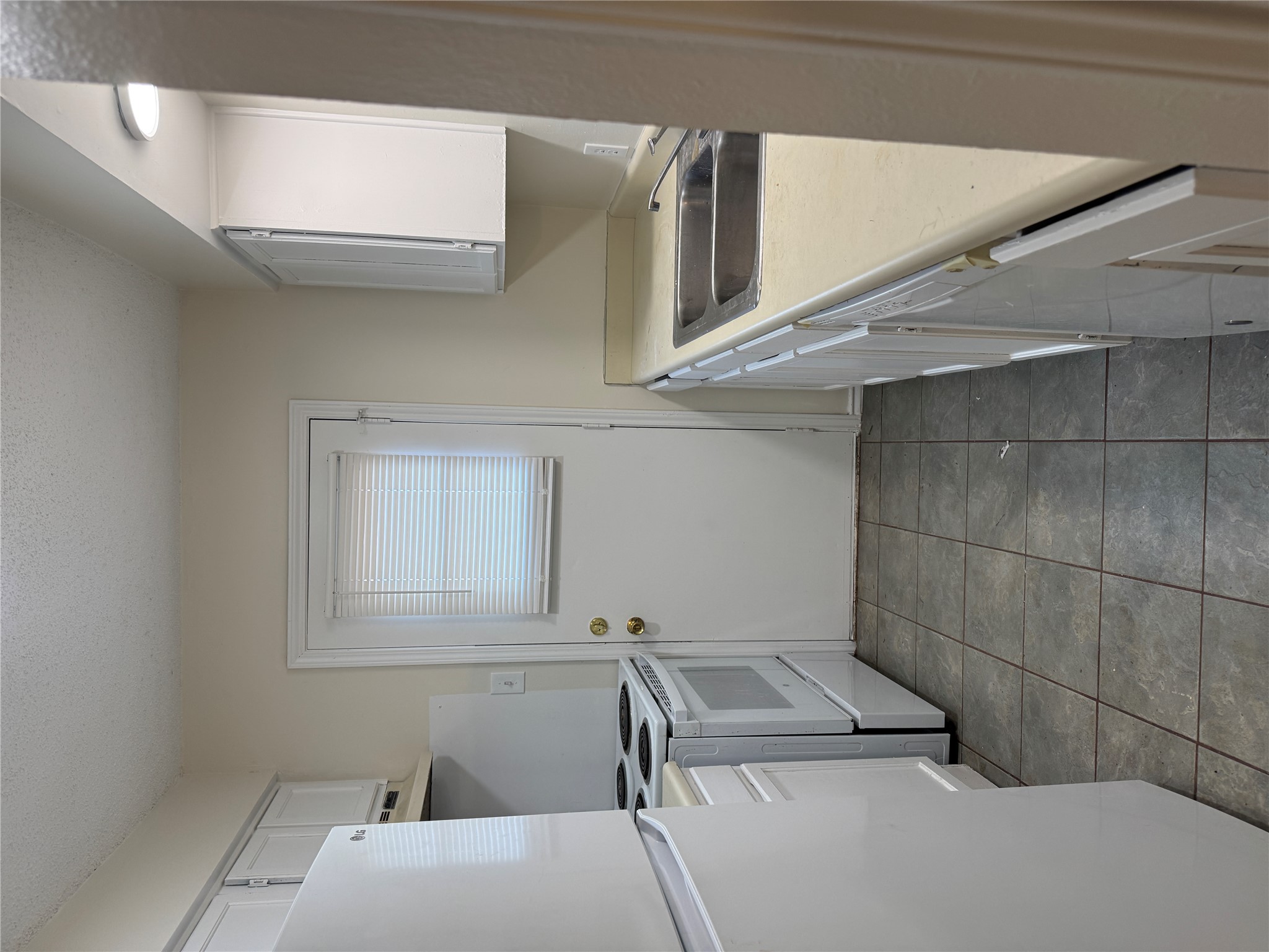 12503 Turtle Rock Road, Unit B Austin, TX 78729 - Photo 6 of 17 a kitchen with a sink a stove top oven and white stainless steel appliances