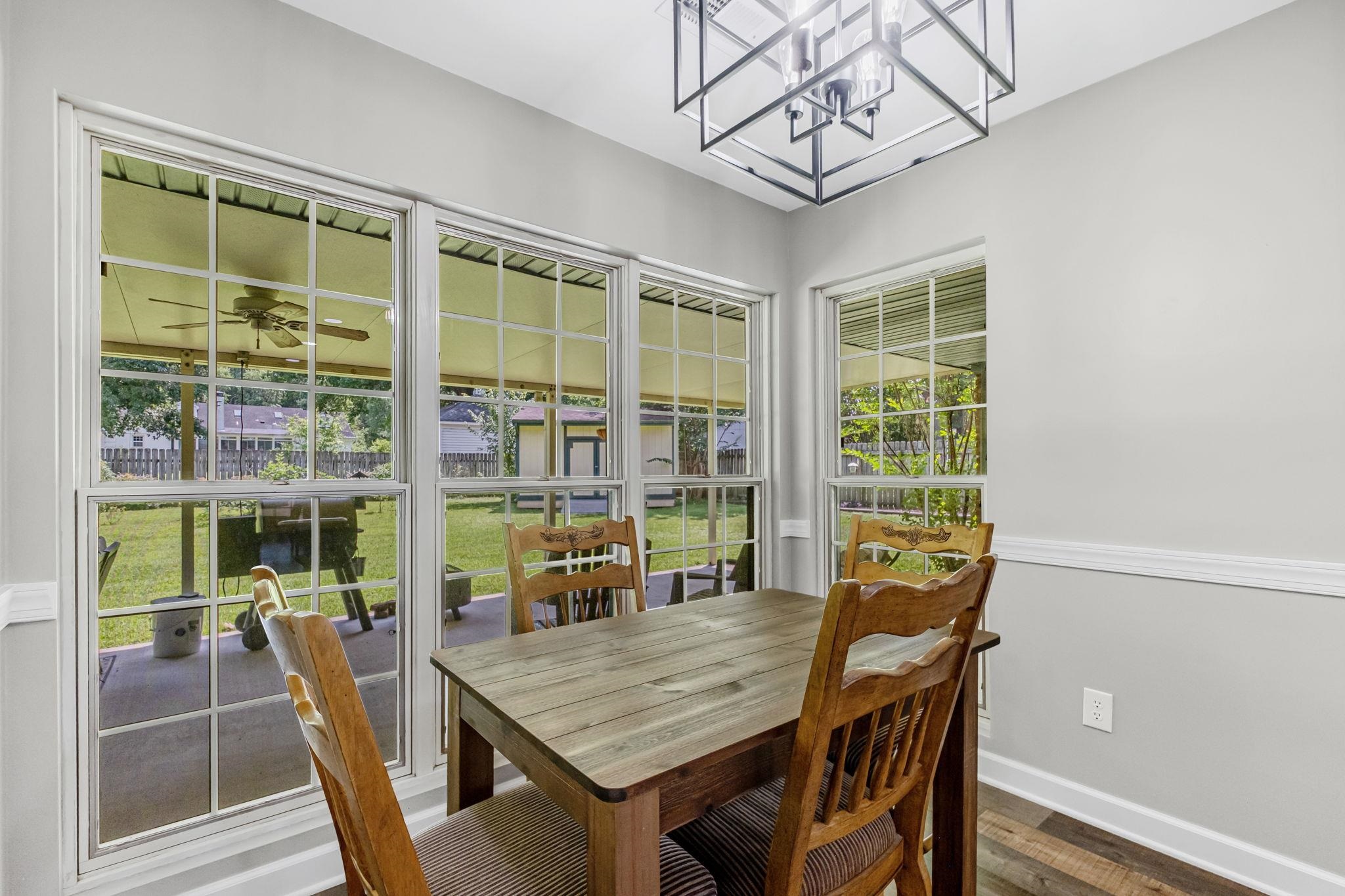 4729 Cedar Ridge Drive Millington, TN 38053 - Photo 12 of 40 Dining area featuring multiple large windows with muntins, a contemporary ceiling light fixture, light gray wall paint, and wood-finish flooring