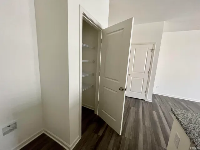 an empty room with wooden floor and closet