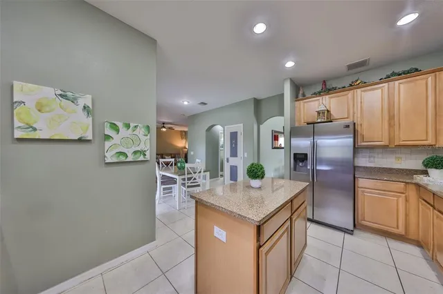 a kitchen with kitchen island granite countertop wooden cabinets a counter top space and stainless steel appliances