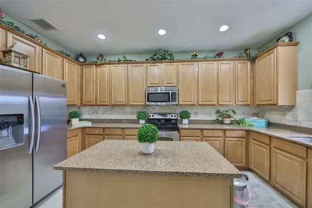a kitchen with a dining table chairs and refrigerator