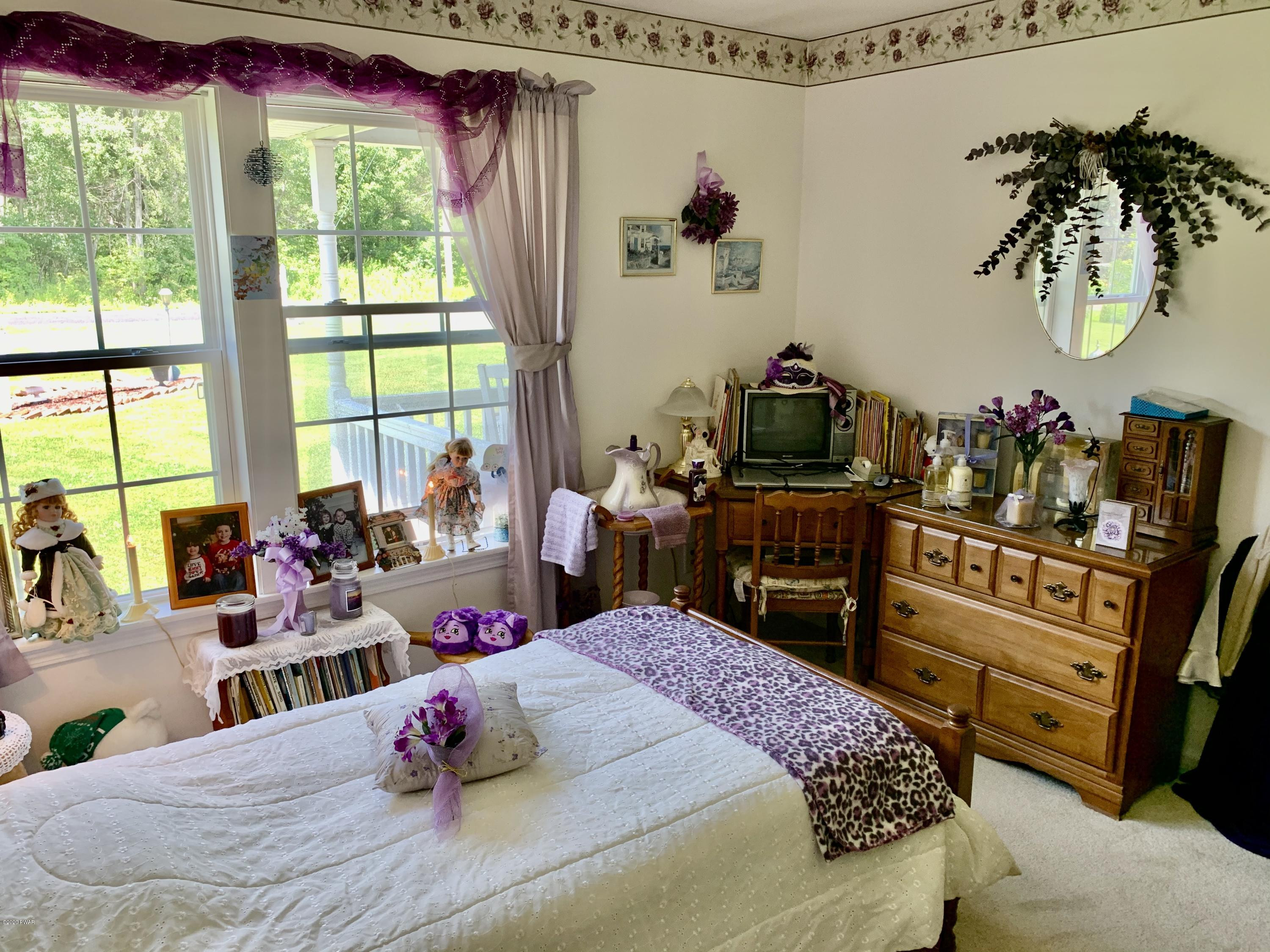 678 Stock Farm Road Lake Ariel, PA 18436 - Photo 32 of 41 a bedroom with a bed and wooden floor