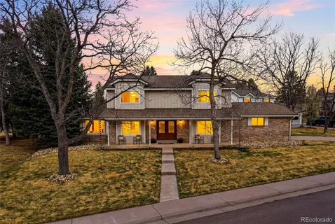 a front view of a house with trees and houses