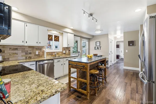 a kitchen with stainless steel appliances granite countertop a sink stove and refrigerator