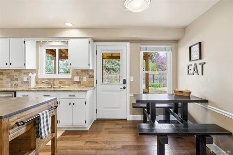 a kitchen with granite countertop a stove dining table chairs and granite counter tops