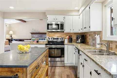 a kitchen with a sink a stove and cabinets